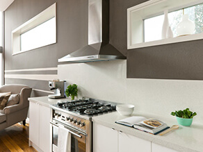 Neutral_brown_kitchen_stone_benchtop_white_windowsills_silver_stove_bulkhead_timber_floorboards